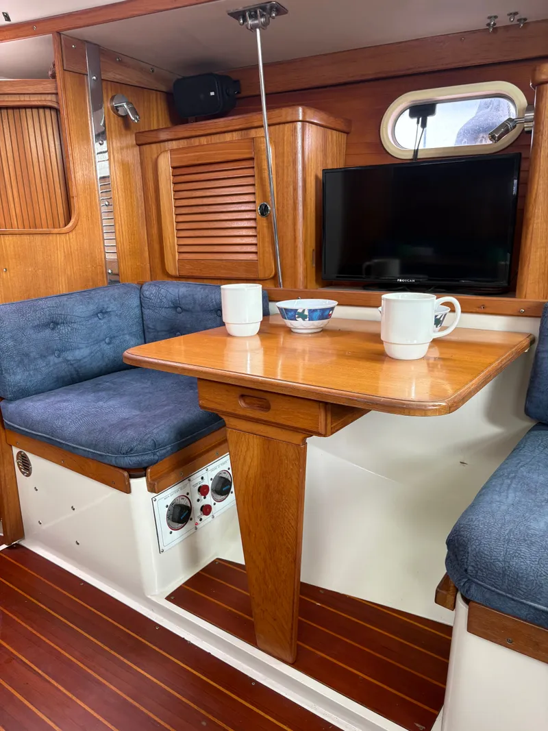 Slide: The Image of Interior of a 2000 Catalina 36 MkII yacht with wooden table and blue cushions. - 31
