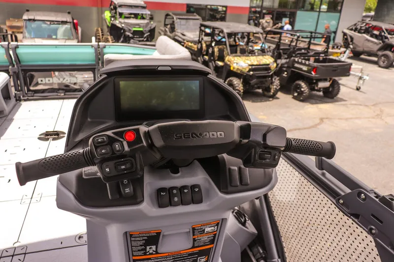 Slide: The Image of 2026 Sea-Doo Switch Cruise 21 dashboard with controls and display, surrounded by off-road vehicles. - 16