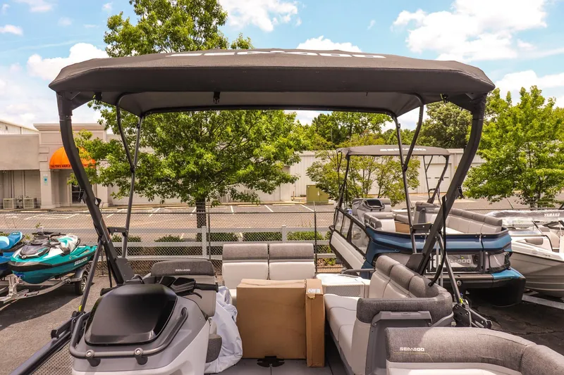 Slide: The Image of 2026 Sea-Doo Switch Cruise 21 pontoon boat with canopy, parked outdoors. - 18
