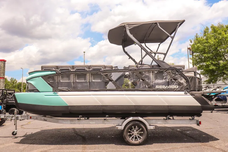 Slide: The Image of 2026 Sea-Doo Switch Cruise 21 pontoon boat on trailer, under cloudy sky. - 6