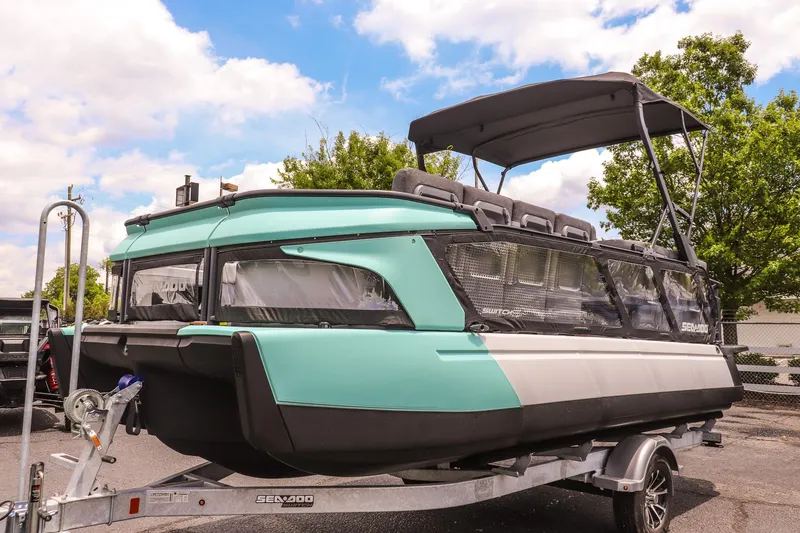 Slide: The Image of 2026 Sea-Doo Switch Cruise 21 pontoon boat on trailer, parked outdoors. - 7