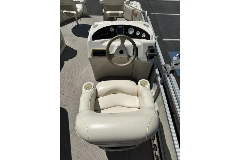 Slide: The Image of 2004 Bennington 2075 FS boat helm with steering wheel and cushioned captain's chair. - 14