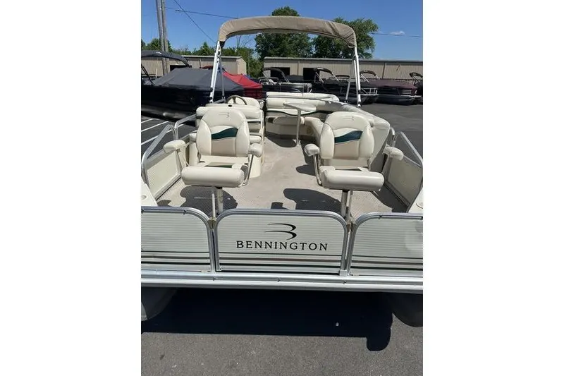Slide: The Image of 2004 Bennington 2075 FS pontoon boat with beige seating and canopy in a parking lot. - 7