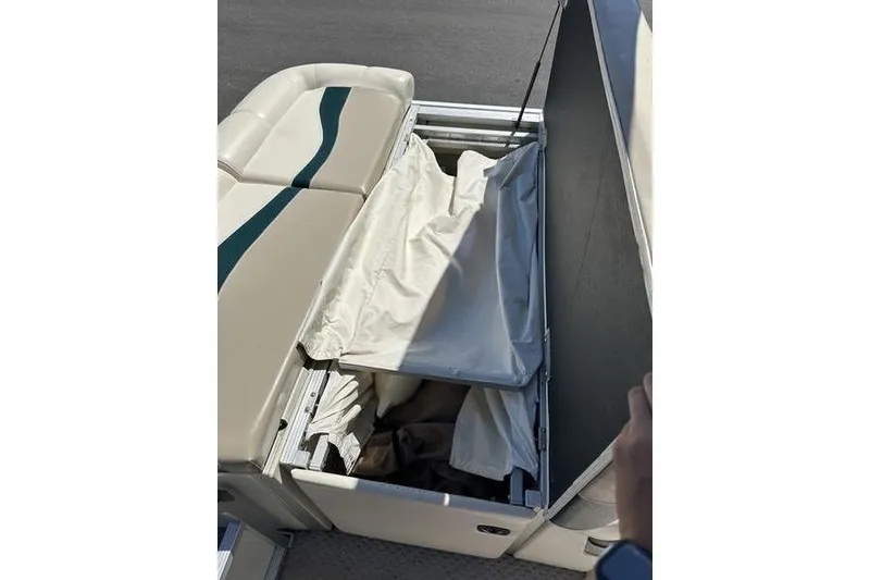 Slide: The Image of 2004 Bennington 2075 FS boat seat storage compartment with open lid and fabric inside. - 8