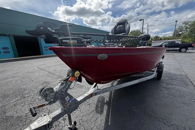 Slide: The Image of 2026 Lund 1650 Angler SS boat on trailer, red exterior, Minn Kota motor, outdoor setting. - 3