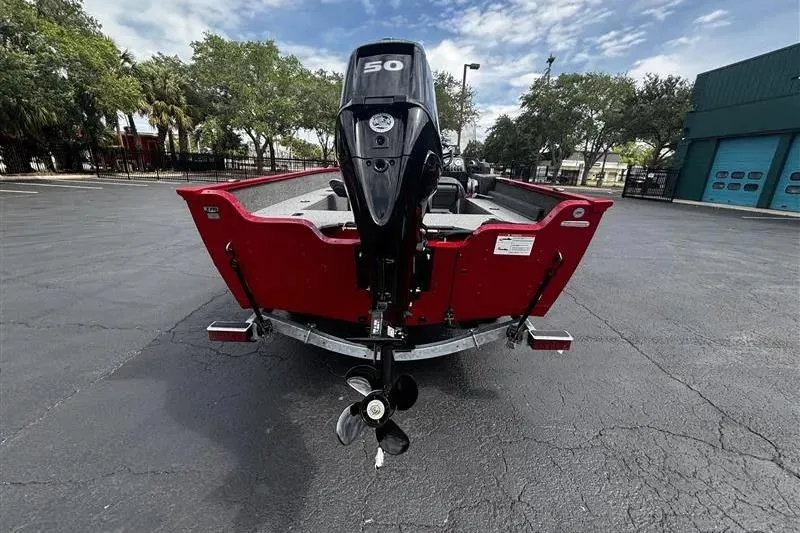 Slide: The Image of 2026 Lund 1650 Angler SS boat with 50 HP motor, parked outdoors. - 4