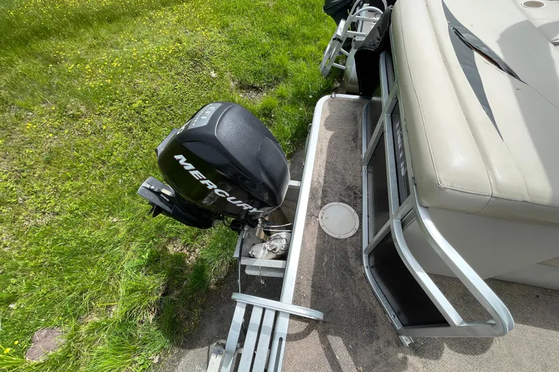 Slide: The Image of 2010 Harris FloteBote 200 Cruiser CX with Mercury outboard motor on grassy area. - 6