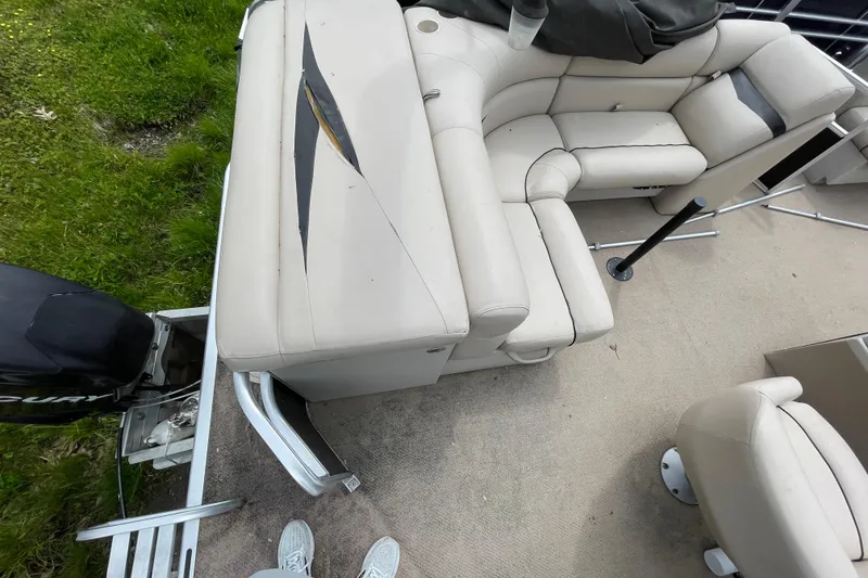 Slide: The Image of 2010 Harris FloteBote 200 Cruiser CX interior with beige seating and visible wear. - 7