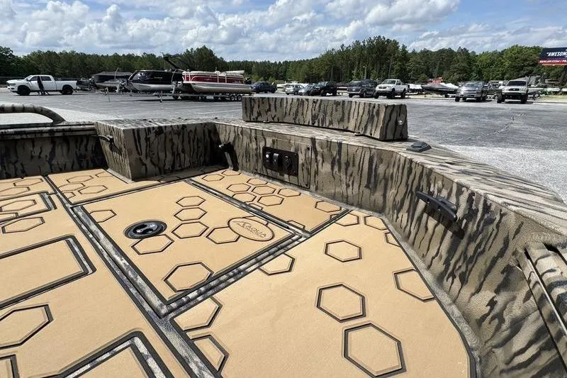 Slide: The Image of 2026 Excel 183 Tomahawk boat interior with hexagonal pattern flooring, parked outdoors. - 11