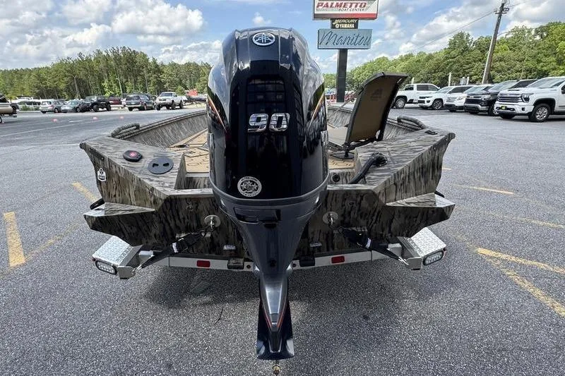 Slide: The Image of 2026 Excel 183 Tomahawk boat with 90 HP engine on trailer in parking lot. - 19