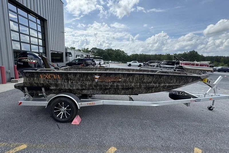 Slide: The Image of 2026 Excel 183 Tomahawk boat on trailer, parked outdoors near a building. - 20