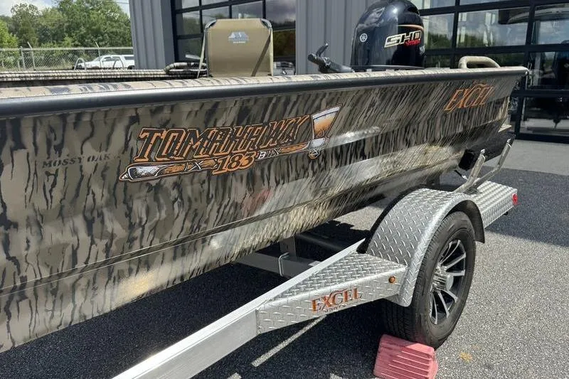 Slide: The Image of 2026 Excel 183 Tomahawk boat with camouflage design on a trailer. - 23