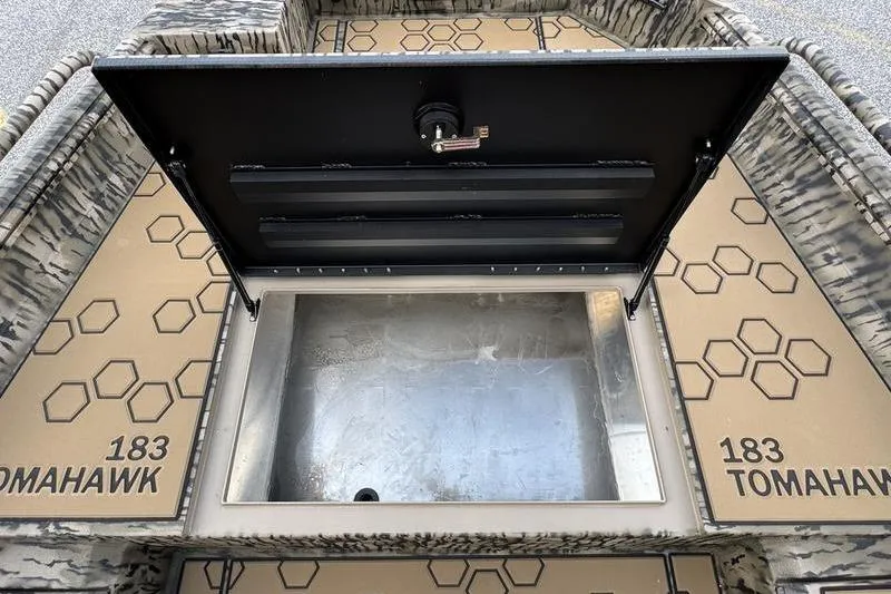 Slide: The Image of Open storage compartment on 2026 Excel 183 Tomahawk boat with hexagonal pattern design. - 9