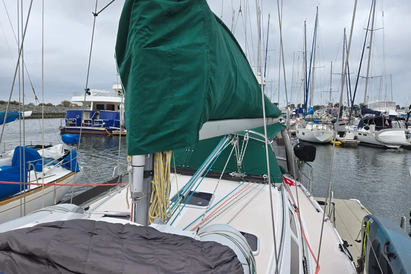 Slide: The Image of Sailboat Catalina 380, 1999 model, docked in a marina with green sail cover. - 11