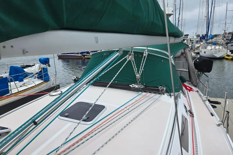Slide: The Image of 1999 Catalina 380 sailboat docked, featuring green canopy and rigging details. - 13