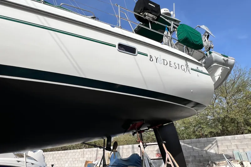 Slide: The Image of 1999 Catalina 380 sailboat named "By Design" on dry dock, side view. - 17
