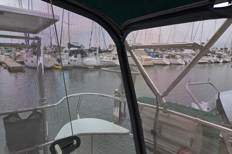 Slide: The Image of View from a 1999 Catalina 380 sailboat cockpit overlooking a marina with docked boats. - 24