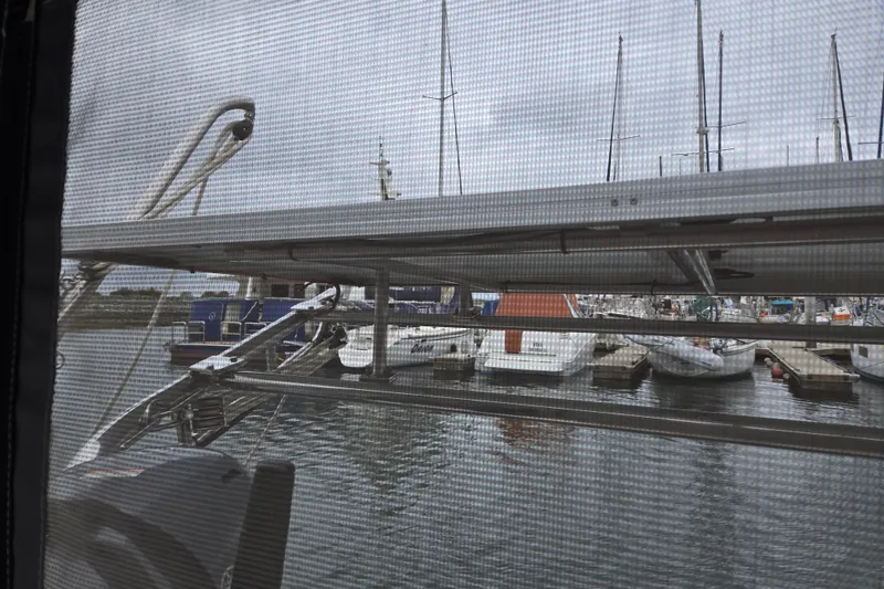Slide: The Image of View from a 1999 Catalina 380 sailboat, overlooking a marina through a mesh screen. - 25