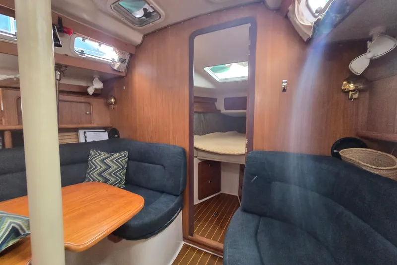 Slide: The Image of Interior of 1999 Catalina 380 sailboat with cozy seating and wooden finishes. - 38