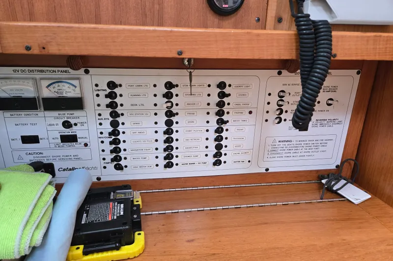 Slide: The Image of Control panel of a 1999 Catalina 380 yacht, featuring switches and gauges. - 42