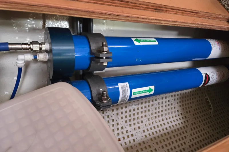 Slide: The Image of Water filtration system in a 1999 Catalina 380 sailboat, featuring blue cylindrical filters. - 49