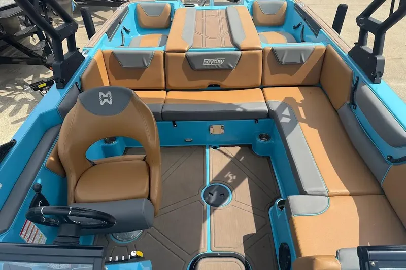 Slide: The Image of 2022 Heyday WT-2DC boat interior with tan and blue seating, steering wheel, and spacious layout. - 10