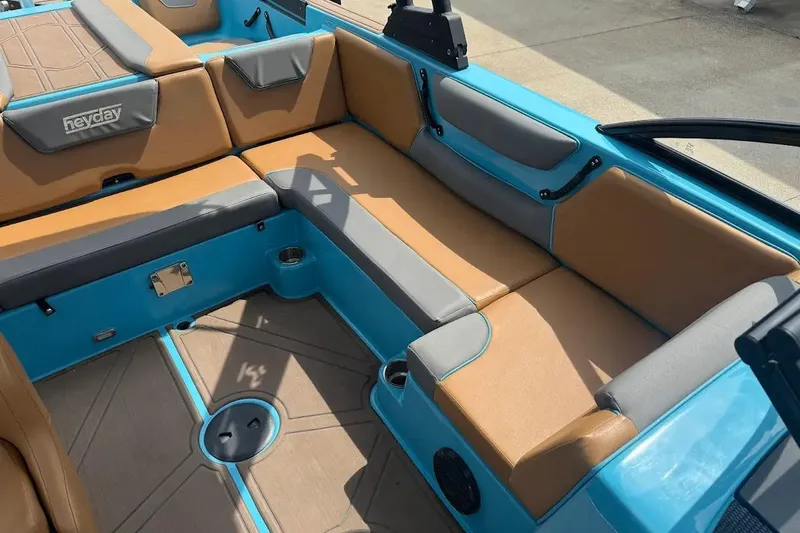 Slide: The Image of 2022 Heyday WT-2DC boat interior with tan and blue seating, cup holders, and Heyday logo. - 17