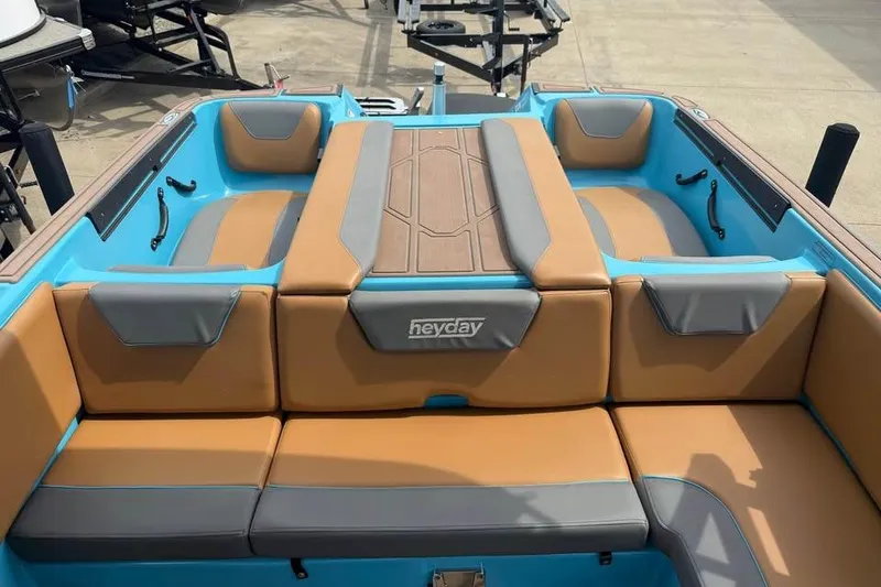 Slide: The Image of 2022 Heyday WT-2DC boat interior with tan and gray seating, blue accents. - 19