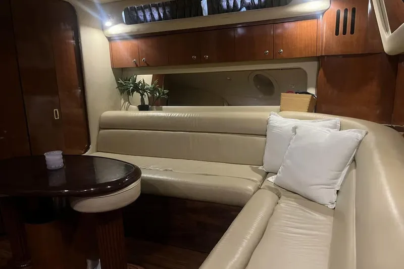Slide: The Image of Luxurious interior of 2003 Sea Ray 410 Express Cruiser with leather seating and wooden cabinetry. - 10