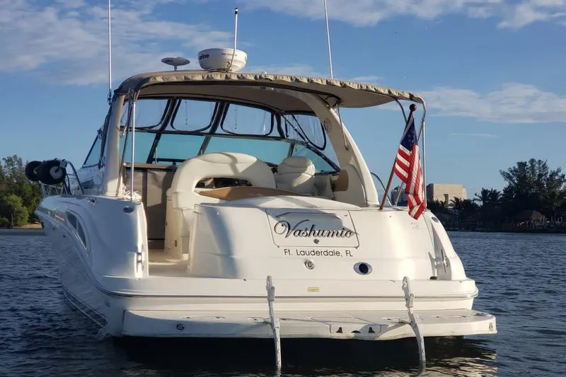 Slide: The Image of 2003 Sea Ray 410 Express Cruiser on water, American flag, sunny day. - 3