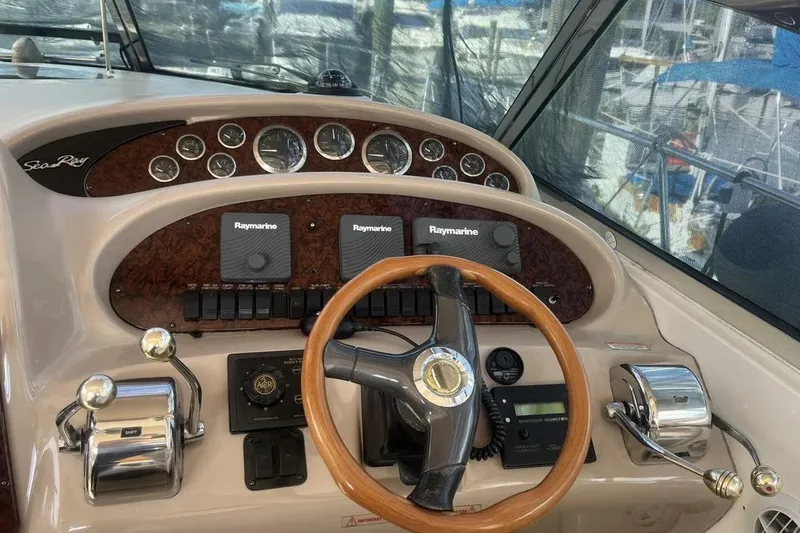 Slide: The Image of 2003 Sea Ray 410 Express Cruiser helm with Raymarine electronics and wooden steering wheel. - 4