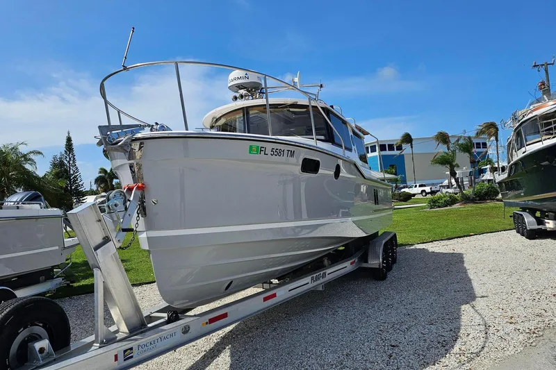 Slide: The Image of 2023 Ranger Tugs boat on trailer, parked outdoors under clear blue sky. - 3