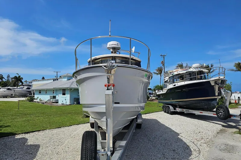 Slide: The Image of 2023 Ranger Tugs boat on trailer, parked outdoors under clear blue sky. - 4