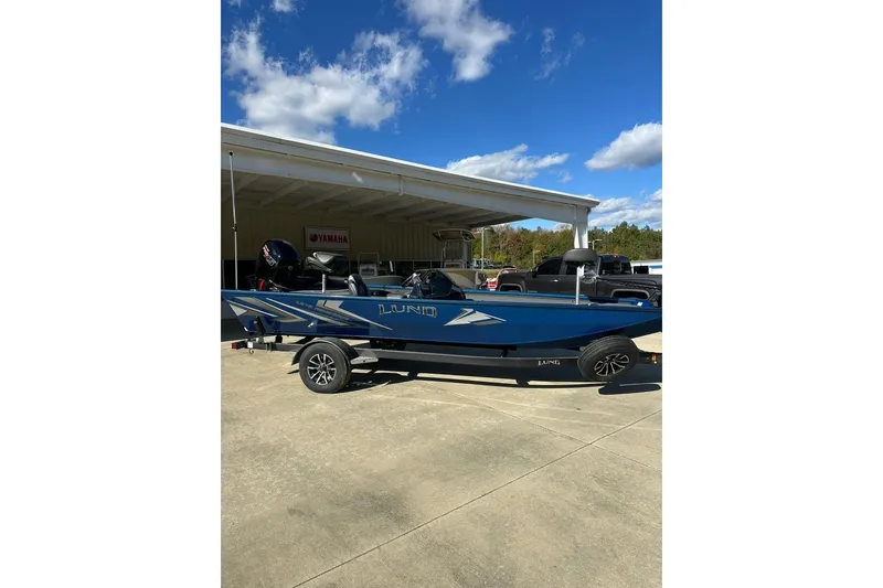 Slide: The Image of Blue 2026 Lund 1975 Renegade boat parked outdoors under a clear sky. - 1