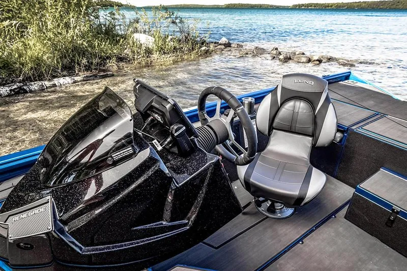 Slide: The Image of Manufacturer Provided Image: 2025 Lund 1975 Renegade boat interior with steering wheel and seat by a lake. - 19