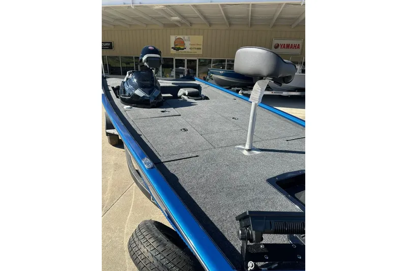 Slide: The Image of 2026 Lund 1975 Renegade boat with gray deck and seating, displayed outdoors. - 2