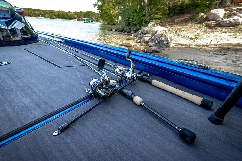Slide: The Image of Manufacturer Provided Image: Fishing rods on a 2025 Lund 1975 Renegade boat by a lakeside. - 22
