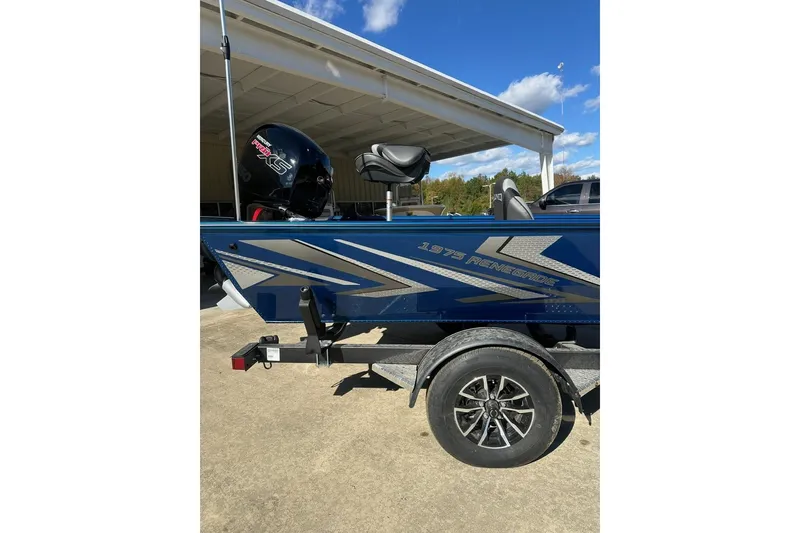 Slide: The Image of Blue 2026 Lund 1975 Renegade boat with trailer, parked outdoors under clear sky. - 4