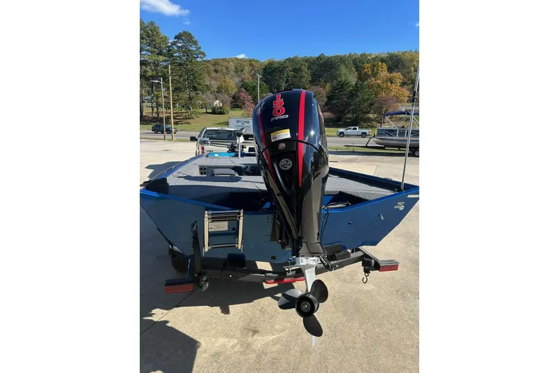 Slide: The Image of Blue 2026 Lund 1975 Renegade boat with outboard motor, parked outdoors. - 6