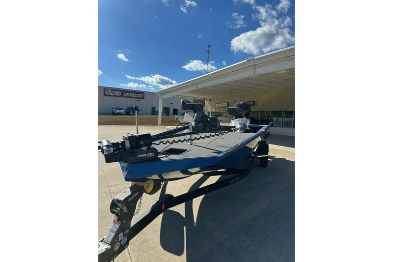 Slide: The Image of 2026 Lund 1975 Renegade boat on trailer, parked outside O'Reilly Auto Parts. - 9