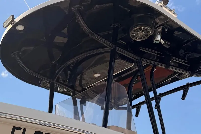 Slide: The Image of 2019 Sea Chaser 24 HFC boat with T-top and speakers against blue sky. - 3