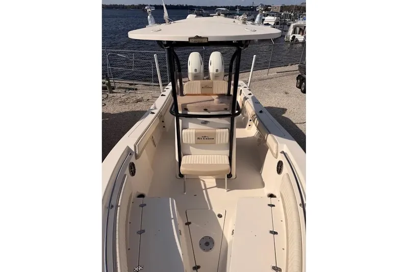 Slide: The Image of 2019 Sea Chaser 24 HFC boat with spacious deck and seating, docked by the water. - 8