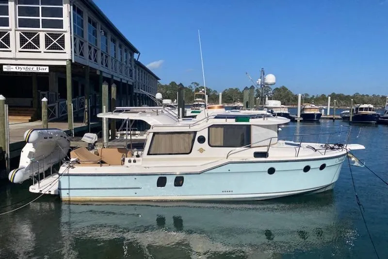 The Image of 2020 Ranger Tugs R-29 S docked at marina near waterfront building. - 1