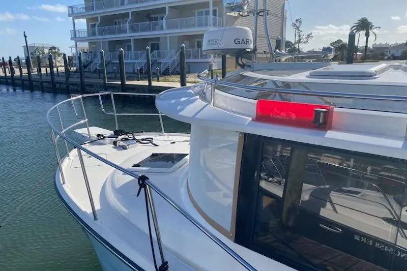 Slide: The Image of 2020 Ranger Tugs R-29 S docked near waterfront buildings. - 3