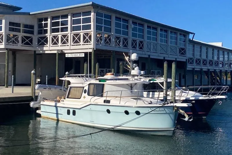 Slide: The Image of 2020 Ranger Tugs R-29 S docked near waterfront building under clear blue sky. - 5