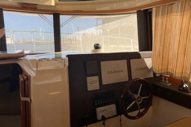 Slide: The Image of 2020 Ranger Tugs R-29 S helm with Garmin navigation system and wooden steering wheel. - 6