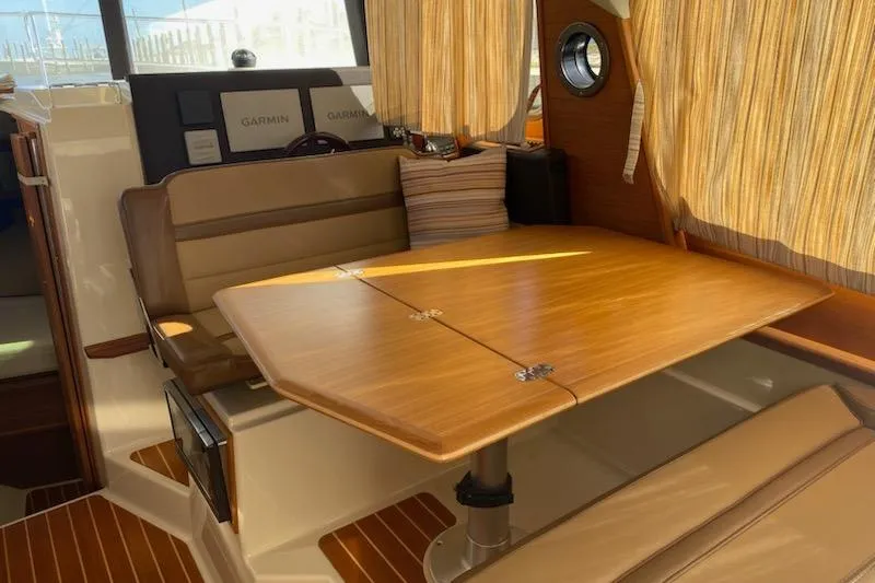 Slide: The Image of 2020 Ranger Tugs R-29 S interior with wooden table and cushioned seating. - 7