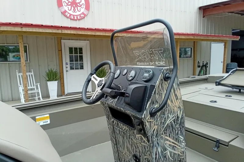 Slide: The Image of 2027 Thor 1900 Bay Hammer boat with camouflage console, parked outside a building. - 38