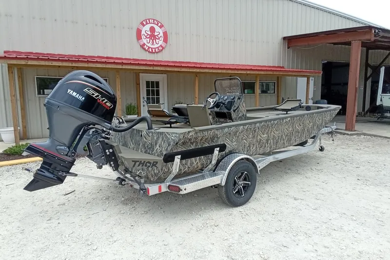 Slide: The Image of 2027 Thor 1900 Bay Hammer boat with Yamaha engine, parked outside a building. - 39