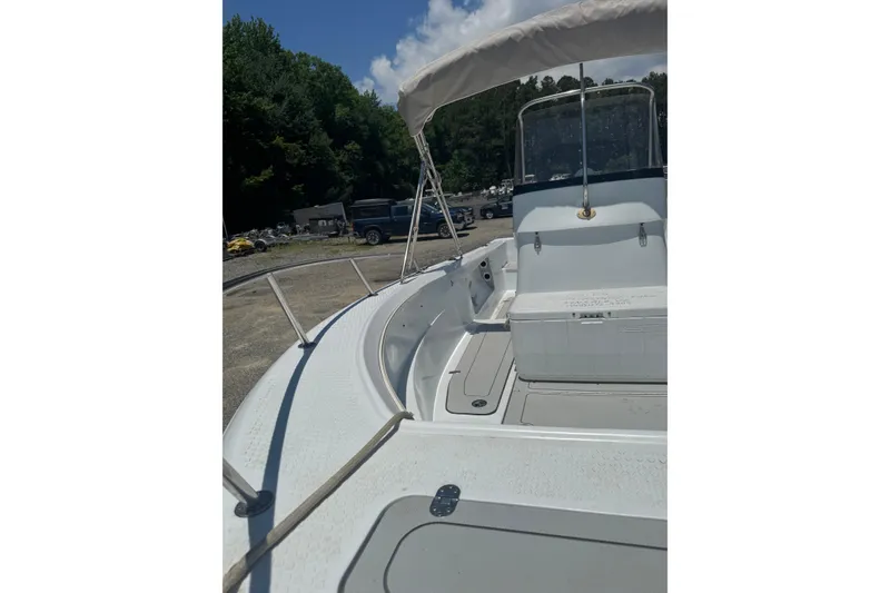 Slide: The Image of 2004 Triumph 210 CC boat with canopy, parked outdoors under blue sky. - 10